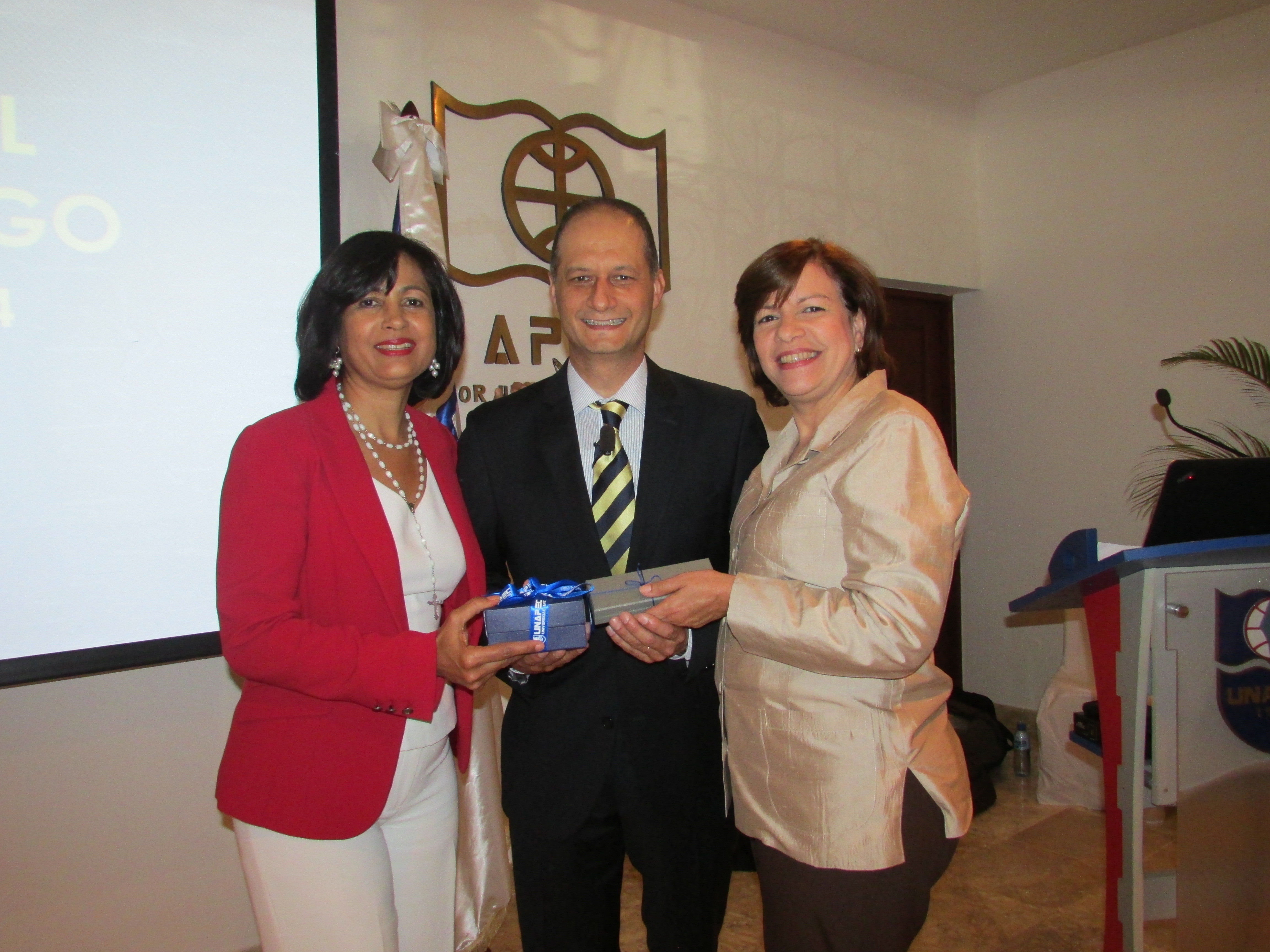 Marisela Almánzar y María Isabel Sánchez mientras entregaban reconocimiento al conferencista Diego Sosa.
