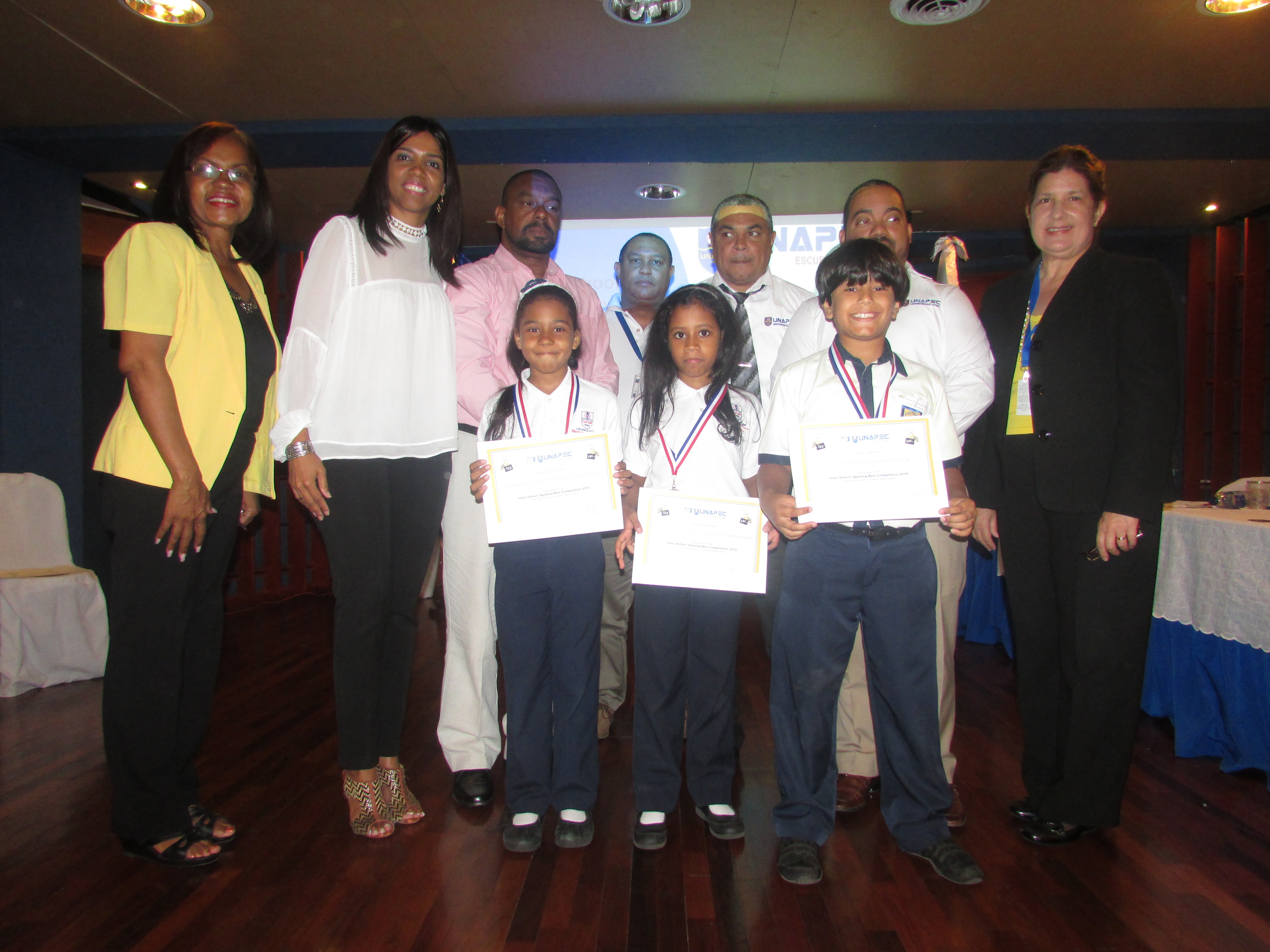 Ganadores de los tres primeros lugares de la primera categoría junto a docentes y autoridades de UNAPEC.