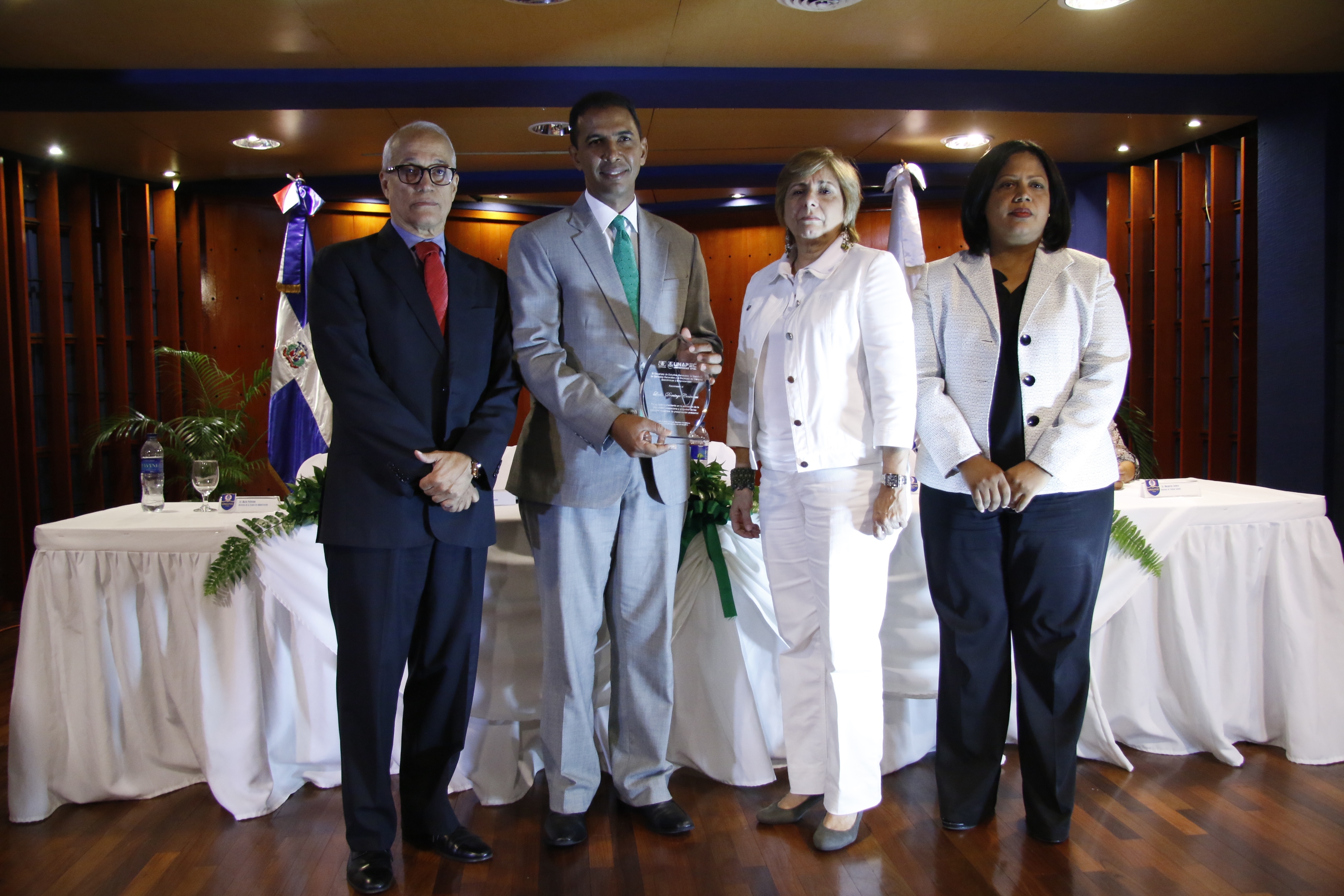 Domingo Contreras recibió la placa de reconocimiento de manos del Dr. Andrés L. Mateo, María Pellerano y Eveliny Alcántara.