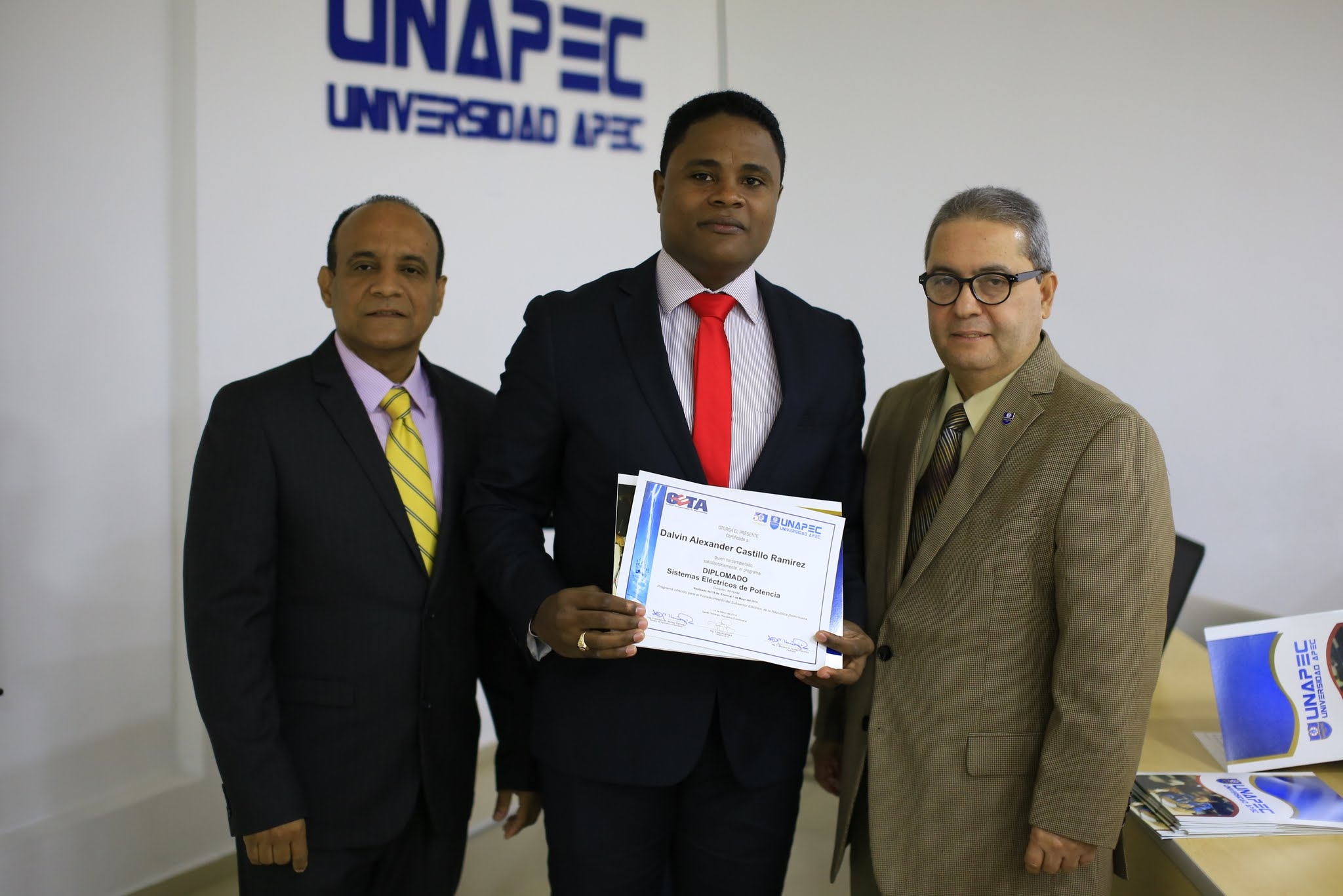 Ing. Dalvin Castillo Ramírez mientras recibe su certificado de manos de directivos de UNAPEC