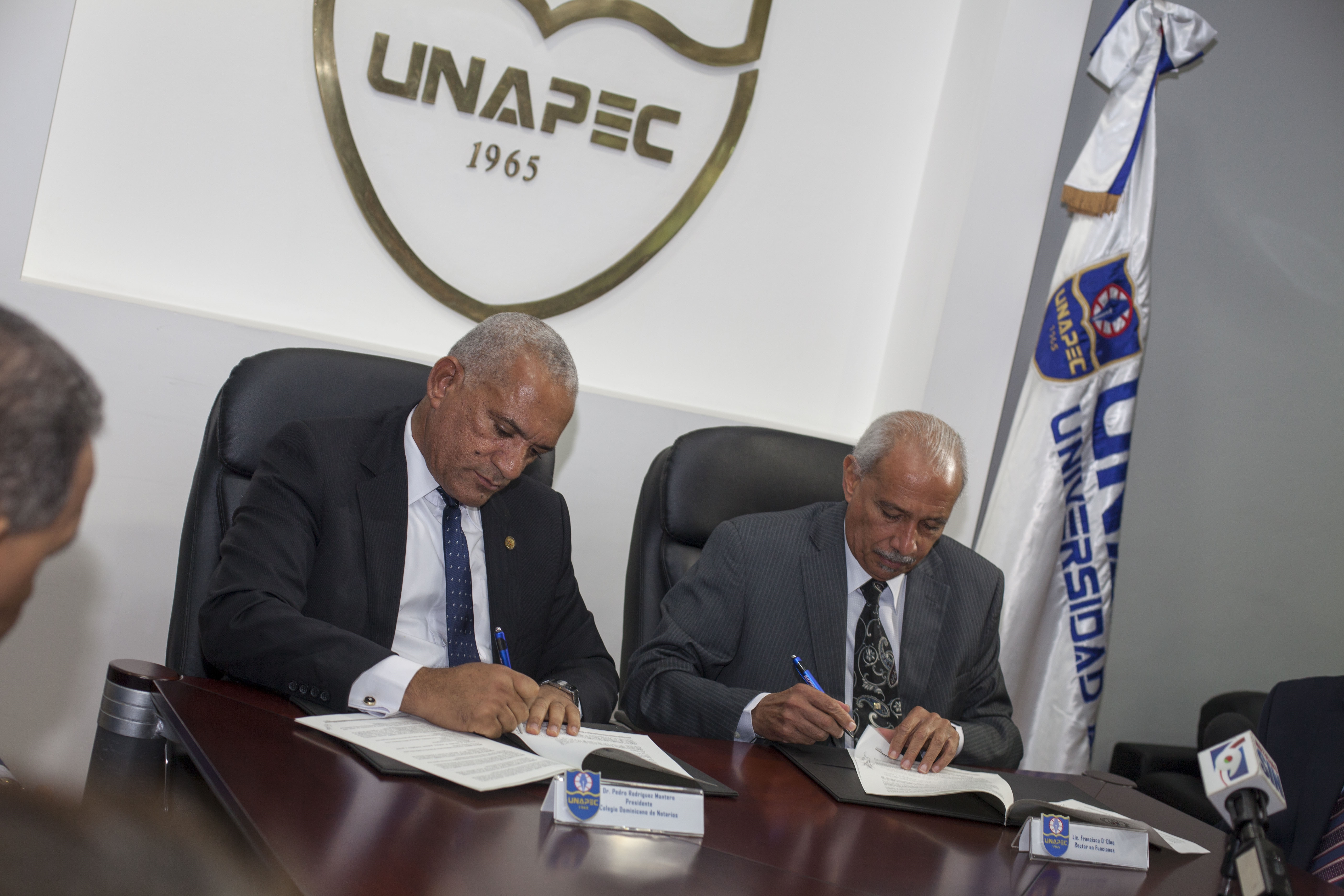 El Rector en Funciones de UNAPEC, Lic. Francisco D`Oleo y Pedro Rodríguez Montero, del Colegio de Notarios, firman el acuerdo. 