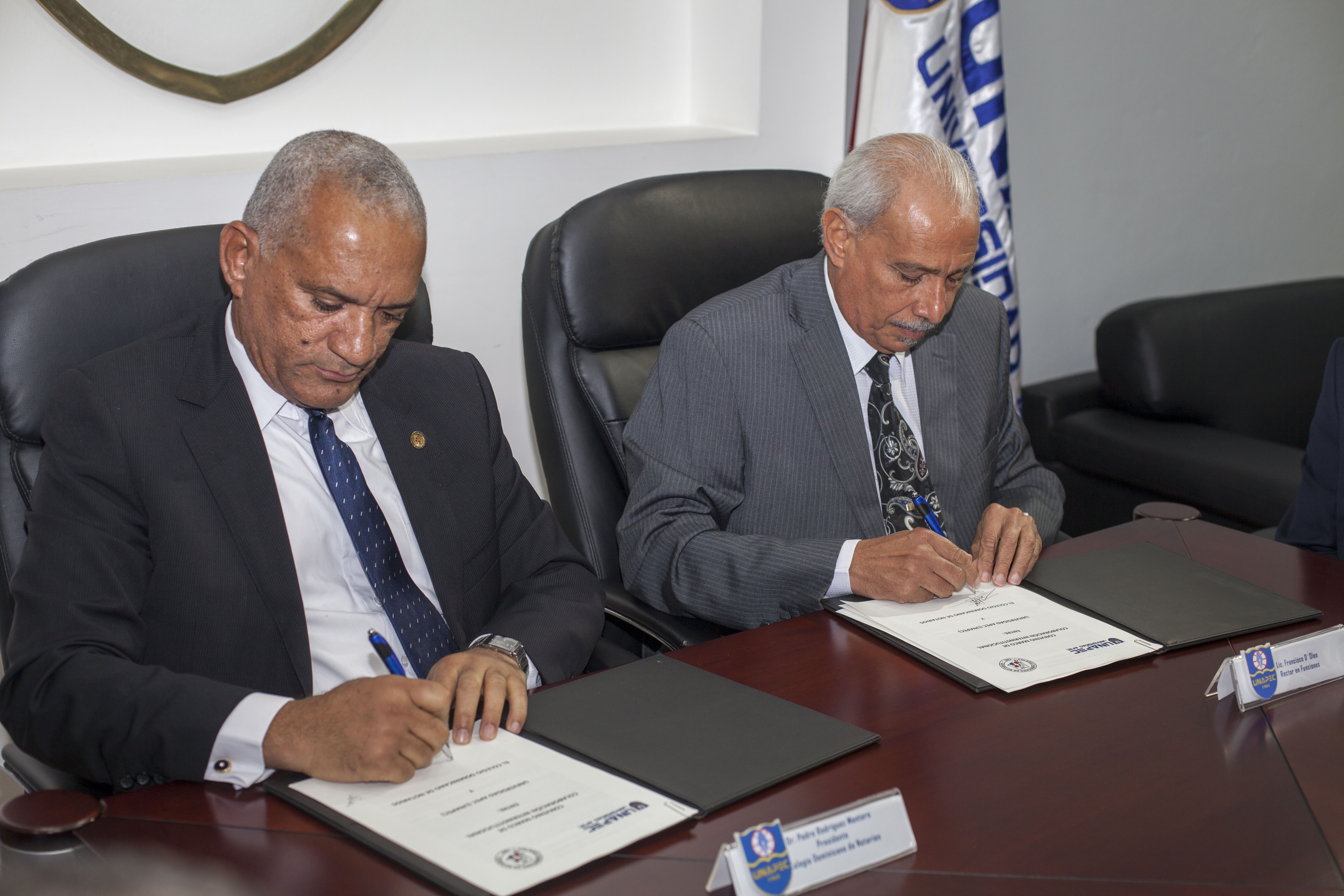 El Rector en Funciones de UNAPEC, Lic. Francisco D`Oleo y Pedro Rodríguez Montero, del Colegio de Notarios, firman el acuerdo. 