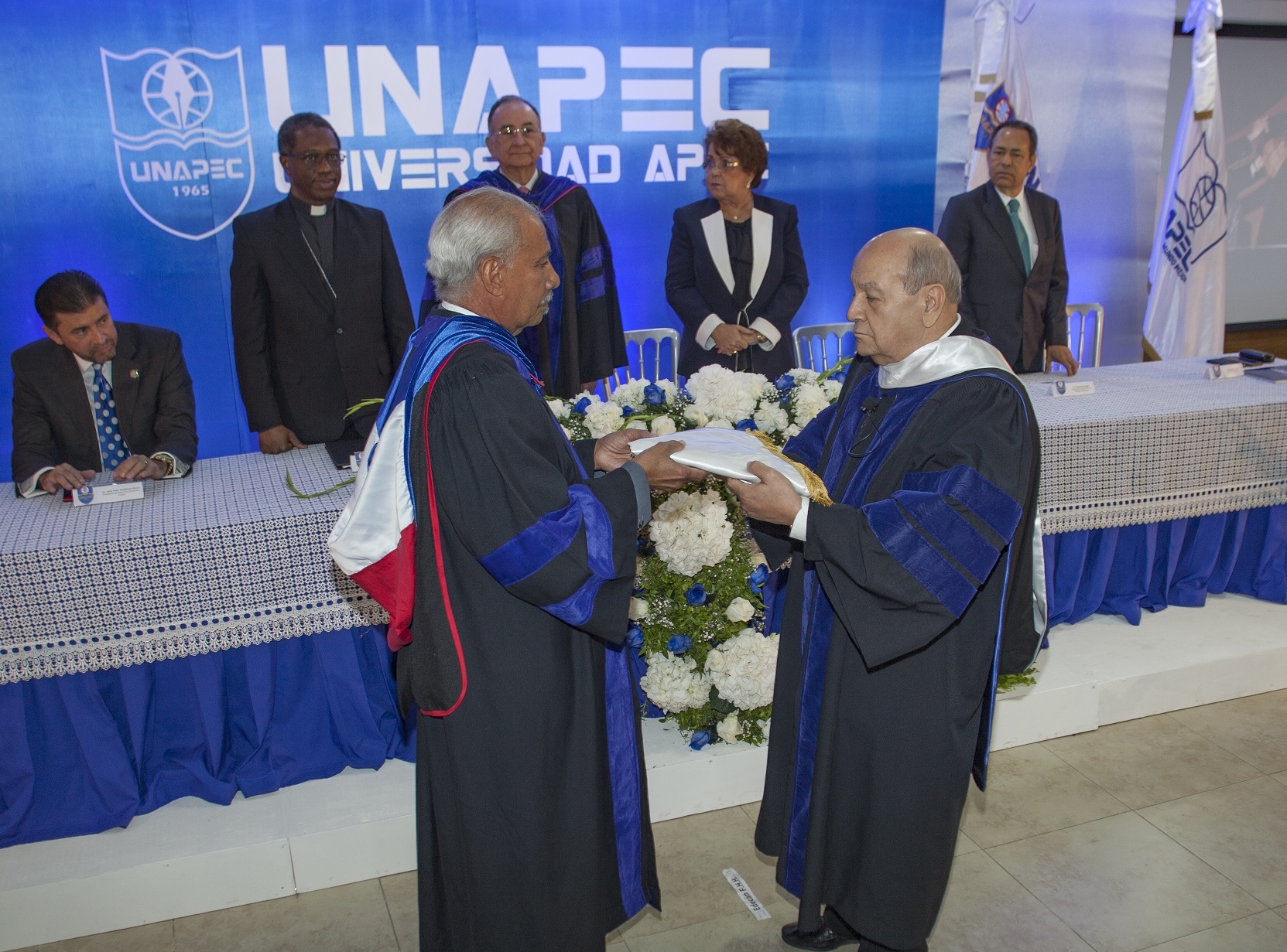 Lic. Francisco D Oleo, Vicerrector Acádemico, entrega Bandera de UNAPEC al nuevo Rector.