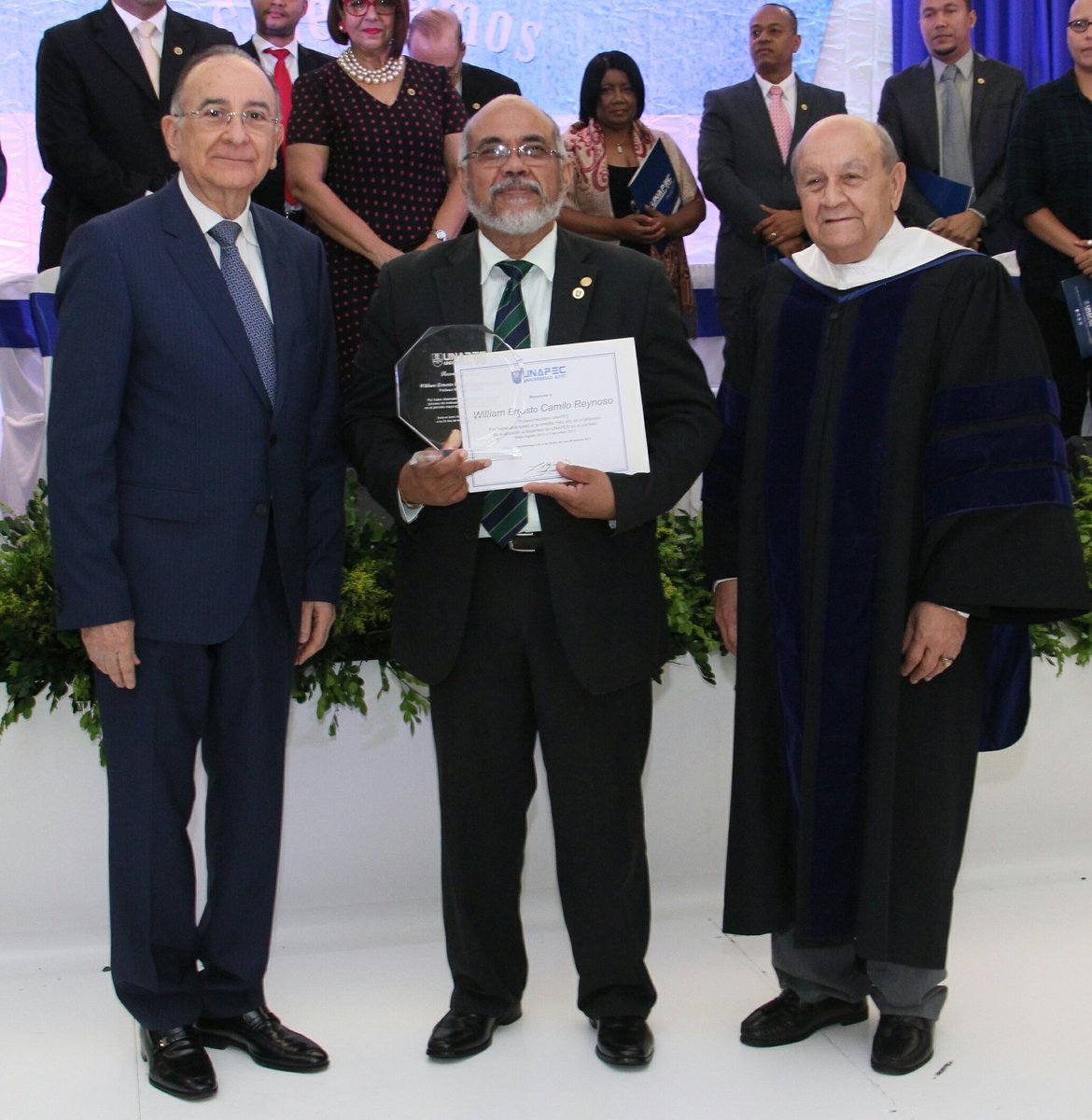 Dr. Franklyn Holguín Haché y el Presidente de la Junta de Directores de UNAPEC, Lic. Opinio Álvarez, entregan placa de reconocimiento al Doctor WILLIAM ERNESTO RAFAEL CAMILO REYNOSO. 